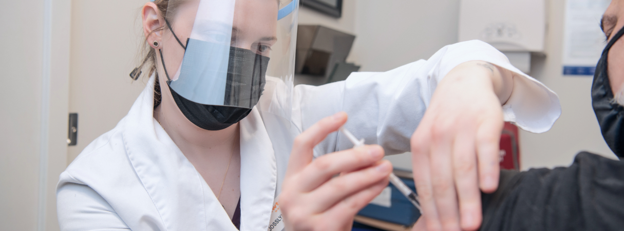 An image of a lady doctor giving Covid vaccination dose to her patient